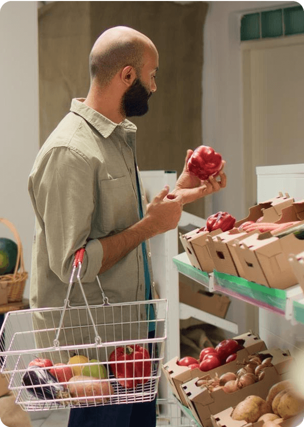 Man picking up an apple while grocery shopping
