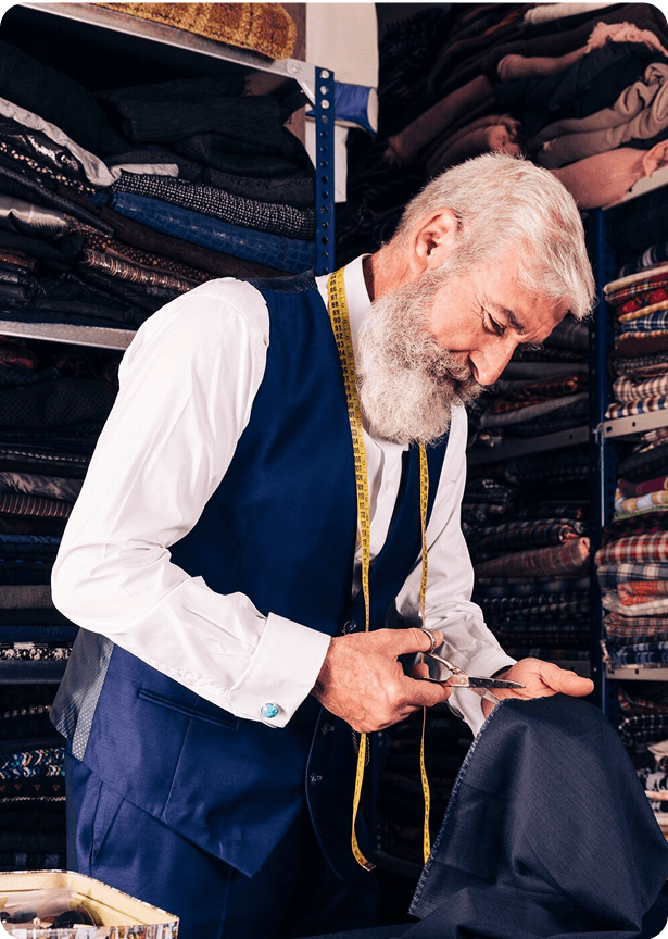 Tailor cutting and sewing clothes