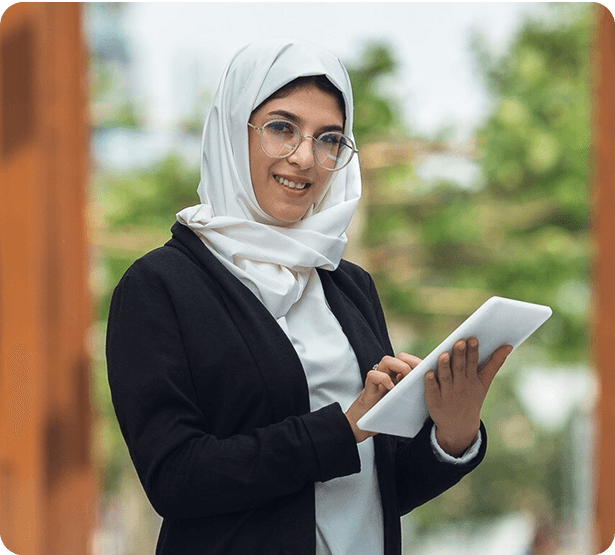 Woman wearing glasses and hijab using a tablet